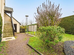 A building with a staircase leading to a door, a mailbox, and a hedge. - Les Sylvestres by Interhome (Cabourg)