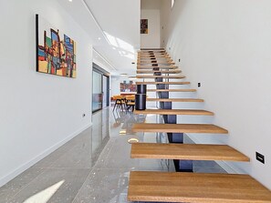 Ein modernes Interieur mit einer Treppe, einem Essbereich und Kunstwerken an den Wänden.