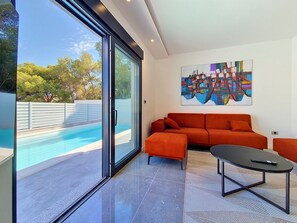 Ein modernes Wohnzimmer mit Pool, einer Couch und einem Couchtisch.
