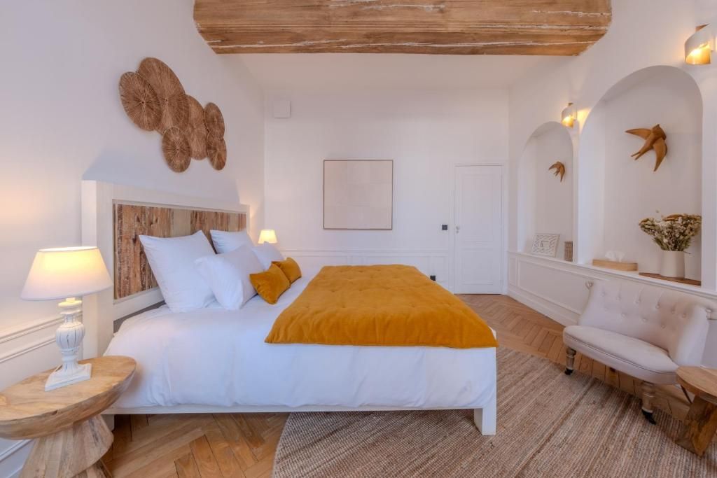 A bedroom with a bed, bedside tables, a chair, and decorative wall art.