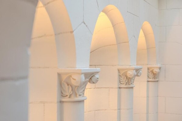A series of white columns with ornate capitals, set against a plain wall. - La Salamandre (Orléans)