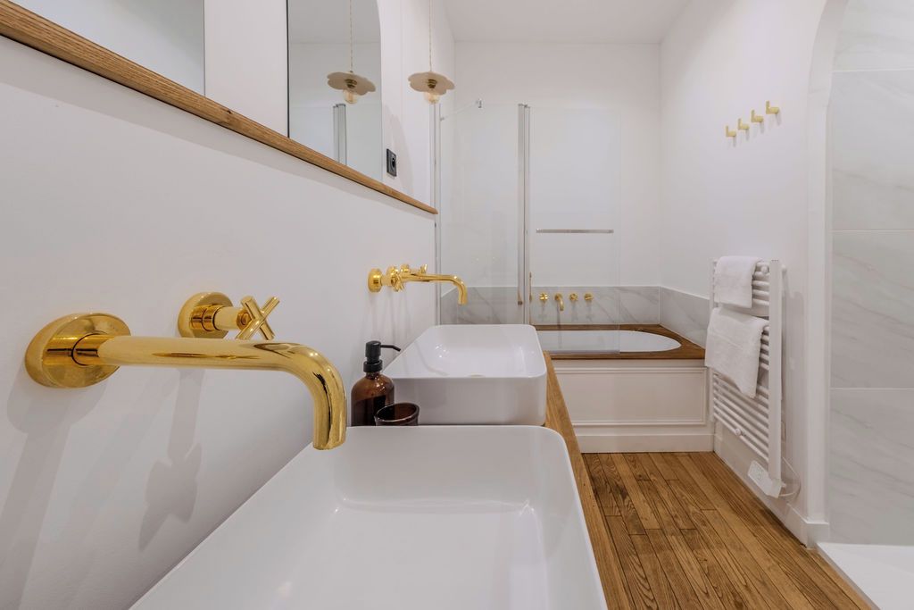 A modern bathroom with a large white sink, a bathtub, and a shower.
