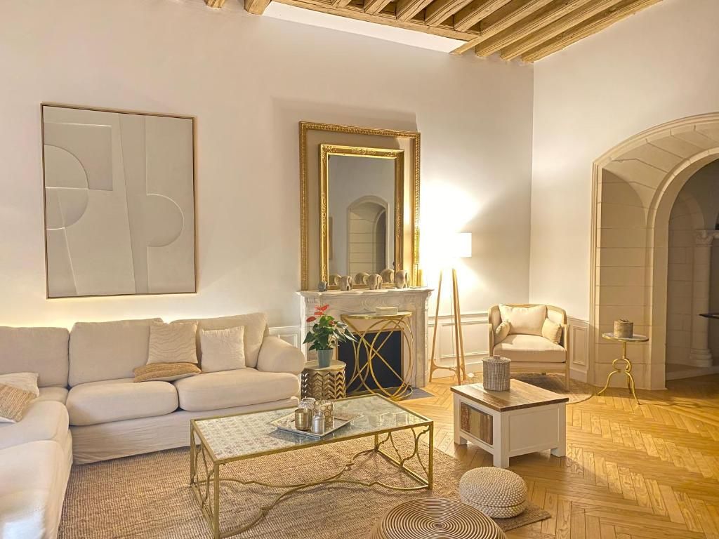 A living room with a sofa, coffee table, fireplace, and a mirror.