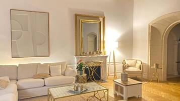 A living room with a sofa, coffee table, fireplace, and a mirror.
