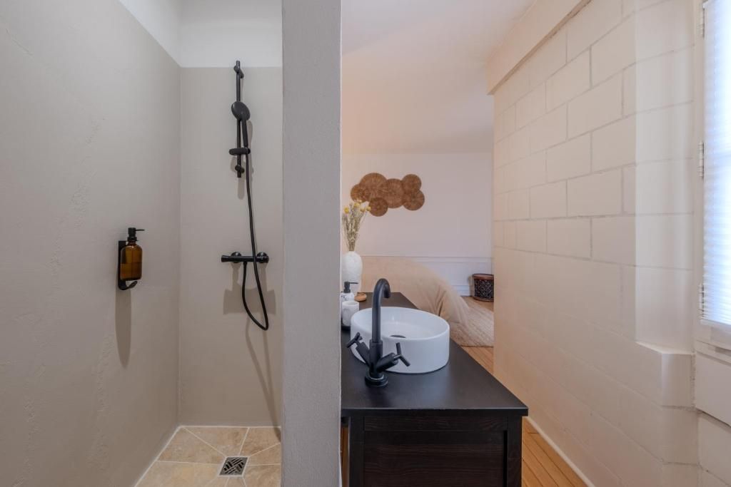 A bathroom with a shower, a sink, and a toilet.