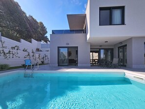 A modern house with a swimming pool, a covered patio, and a view of a hillside. - Aloa II by Interhome (Brač/Splitska)
