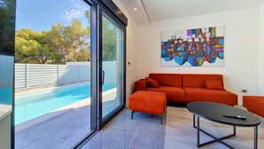 Un salon moderne avec une piscine, un canapé et une table basse.