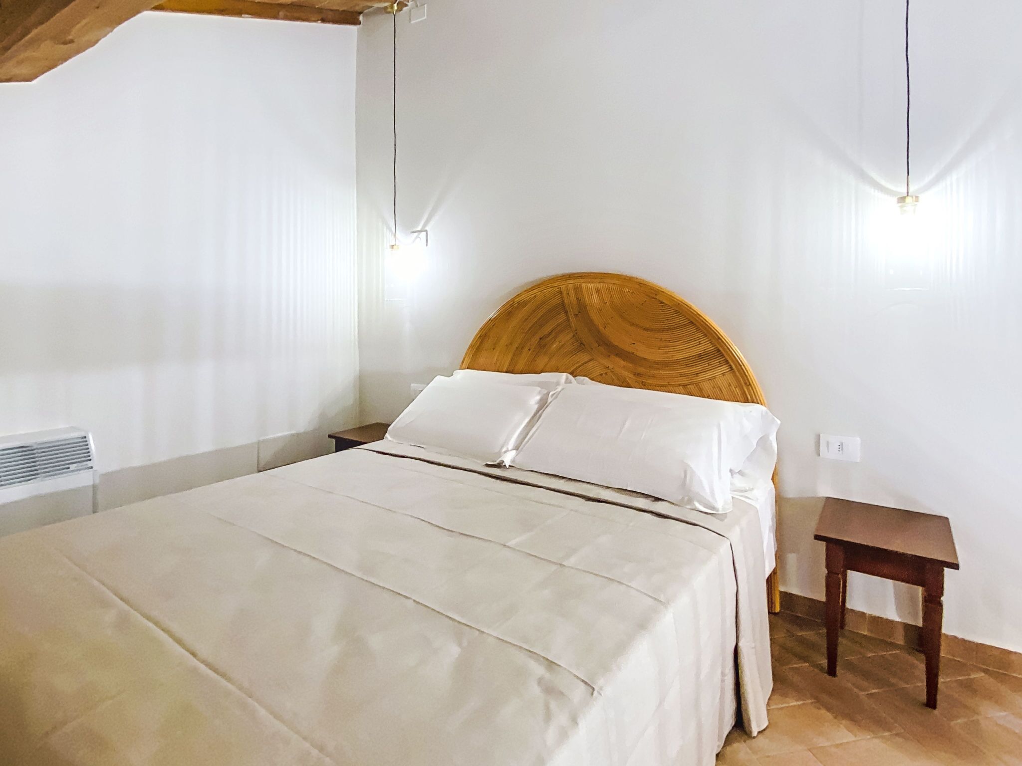 Une chambre à coucher avec un lit, des tables de chevet et une tête de lit en bois.