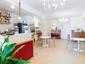Ein modernes Café mit Barbereich, Sitzgelegenheiten und einer Auslage.