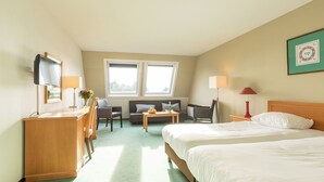 Une chambre d’hôtel équipée d’un lit, d’un bureau, d’une chaise, d’un canapé, d’une table et d’un téléviseur.