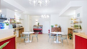 A modern interior with two round tables, chairs, a chandelier, and shelves with bottles. - Casale Bolgherese by Interhome (Bolgheri)