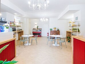A modern interior with two round tables, chairs, a chandelier, and shelves with bottles. - Casale Bolgherese by Interhome (Bolgheri)