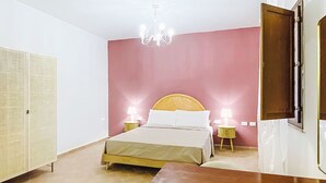A bedroom with a bed, bedside tables, a wardrobe, and a chandelier. - Casale Bolgherese by Interhome (Bolgheri)