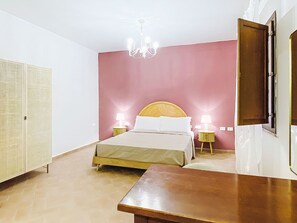 A bedroom with a bed, bedside tables, a wardrobe, and a chandelier. - Casale Bolgherese by Interhome (Bolgheri)