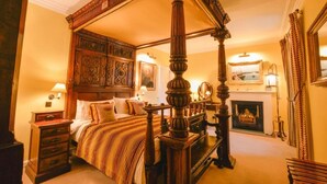 A four-poster bed with a wooden canopy, a fireplace, and a mirror on the wall. - Barcaldine Castle (Oban)