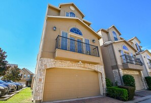 A two-story house with a stone facade, a garage, and a balcony. - Fully Furnished 3BR / 3BA Home Near Medical Center (Houston)