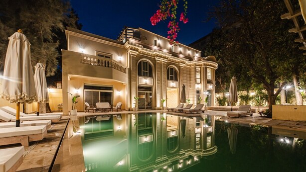 Ein luxuriöses Hotel mit großem Schwimmbad, Außenbereich und ansprechender Architektur.