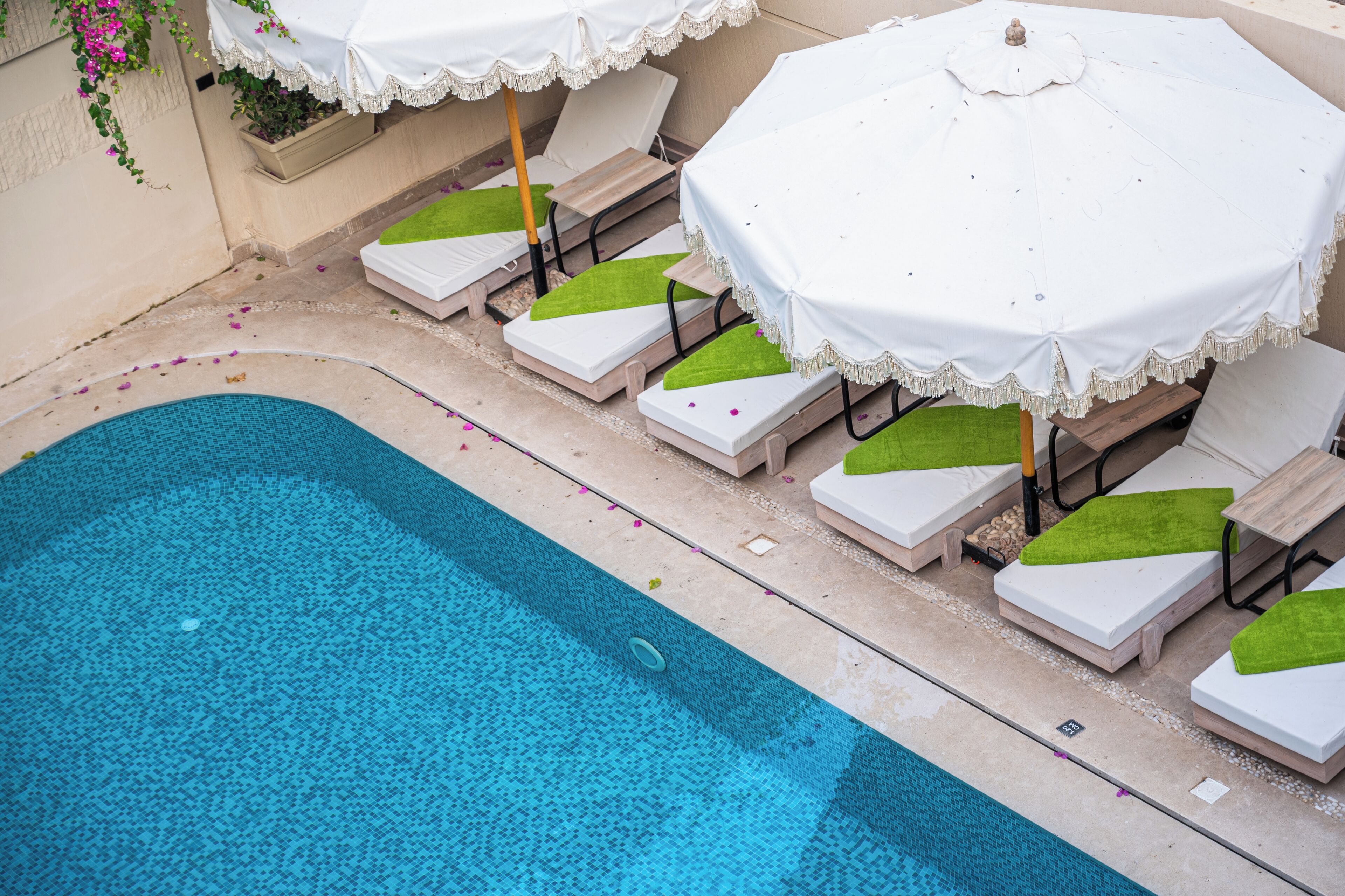 A swimming pool with lounge chairs and umbrellas.