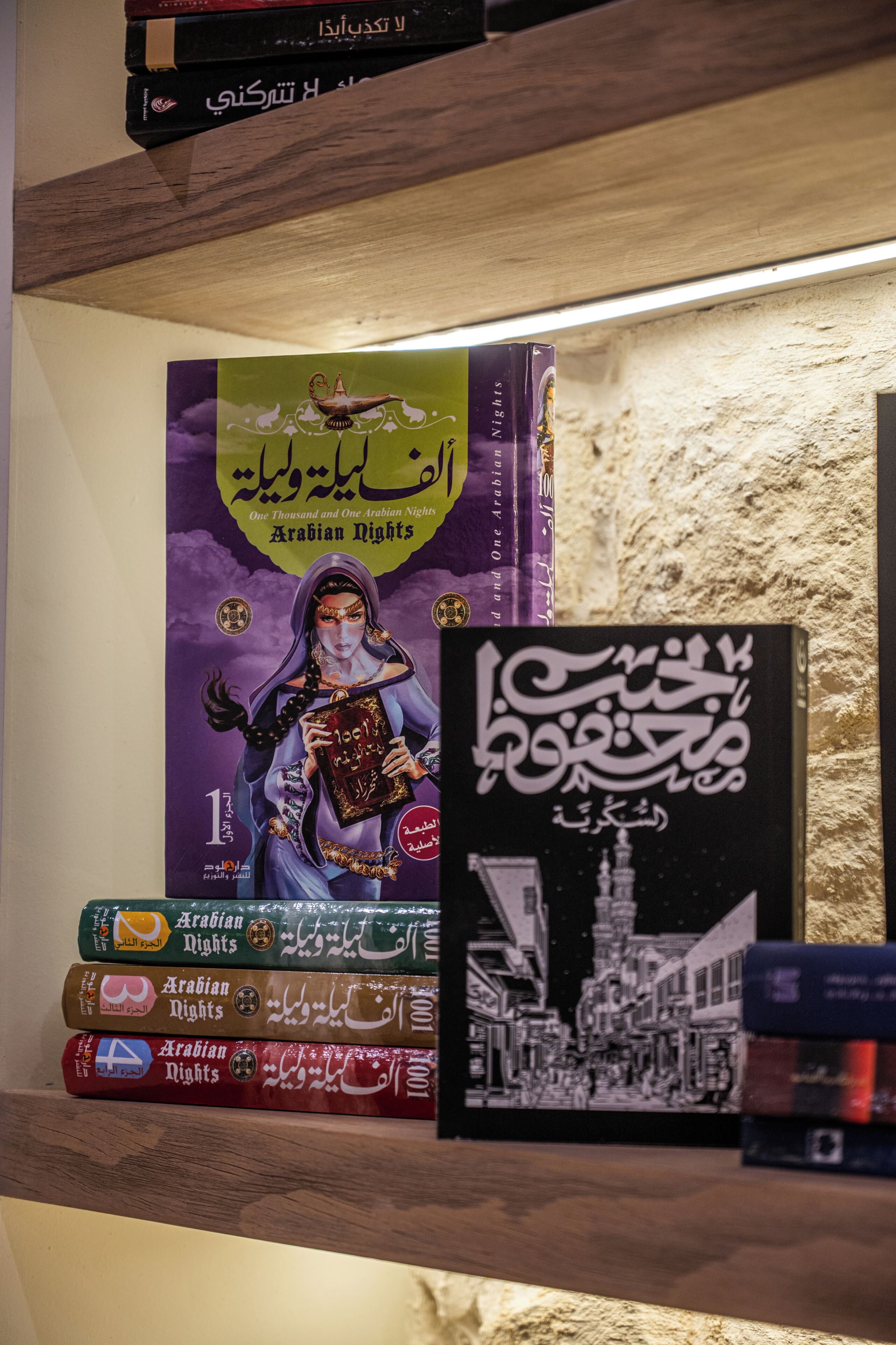 Un montón de libros con el título 'Arabian Nights', con texto árabe e ilustraciones.