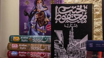 Un montón de libros con el título 'Arabian Nights', con texto árabe e ilustraciones.