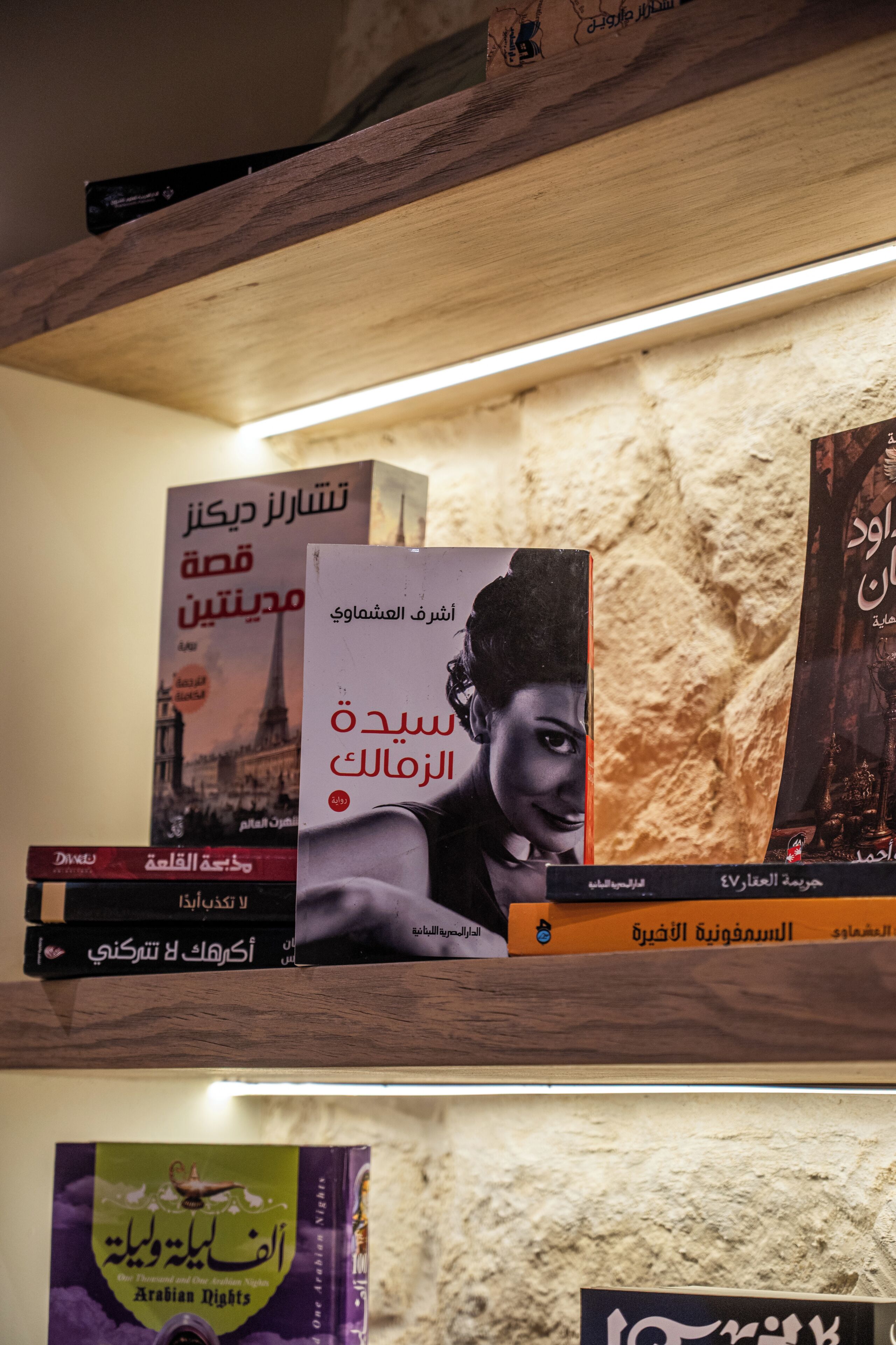 Une bibliothèque remplie de livres, dont un intitulé « Les Mille et Une Nuits ».