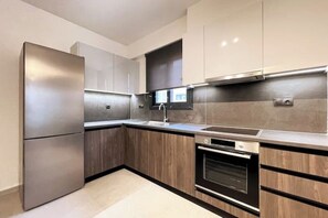 Una cocina moderna con electrodomésticos de acero inoxidable, armarios de madera y un horno empotrado.
