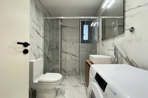 A modern bathroom with a glass-enclosed shower, a toilet, and a sink. - Athenean Gem Near Athens Metro Mall-B2 (Ilioupoli)