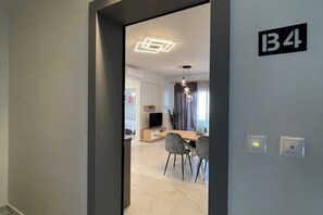 Ein modernes Interieur mit Essbereich, einem Fernseher und einer Wandleuchte.