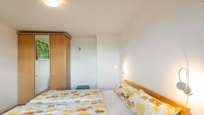 A bedroom with two beds, a wardrobe, and a wall-mounted light fixture. - Alpenblick Apartment (Todtnau)