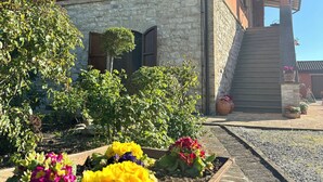 Un bâtiment doté d’une façade en pierre, de volets en bois et d’un porche abrité.