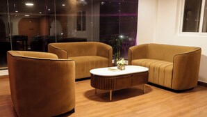 A modern room with a sofa set, a coffee table, and a potted plant. - C Suites Gilbert (Bengaluru)