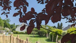 A wooden fence, a grassy yard, and a clear sky. - Guest Room 'L'Abri des Flots' with Shared Pool, Terrace, and Wi-Fi (Plouër-sur-Rance)