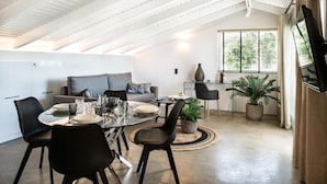 Un loft moderno con comedor, sofá y un ventanal grande.