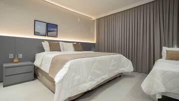 A modern hotel room with a large bed, bedside tables, and a view of the city.