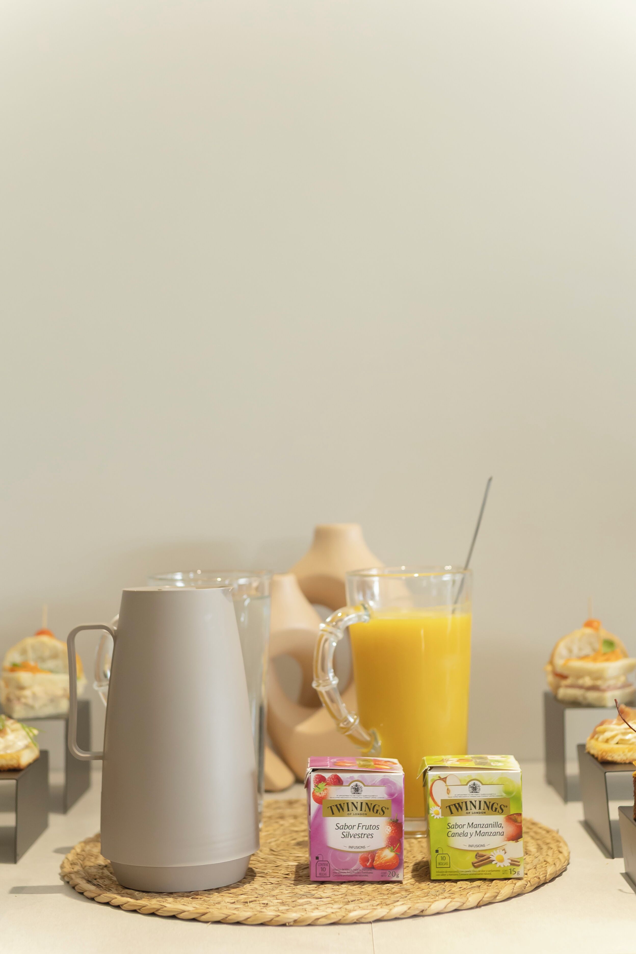 Une table de petit-déjeuner avec un pichet, du jus et des portions individuelles de jus de fruits Twinings.