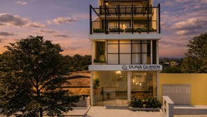A modern hotel with a two-story structure, a visible entrance, and a sign indicating the name 'DUNa Queen Hotel Conceito.' - Duna Queen Hotel Conceito (Barreirinhas)
