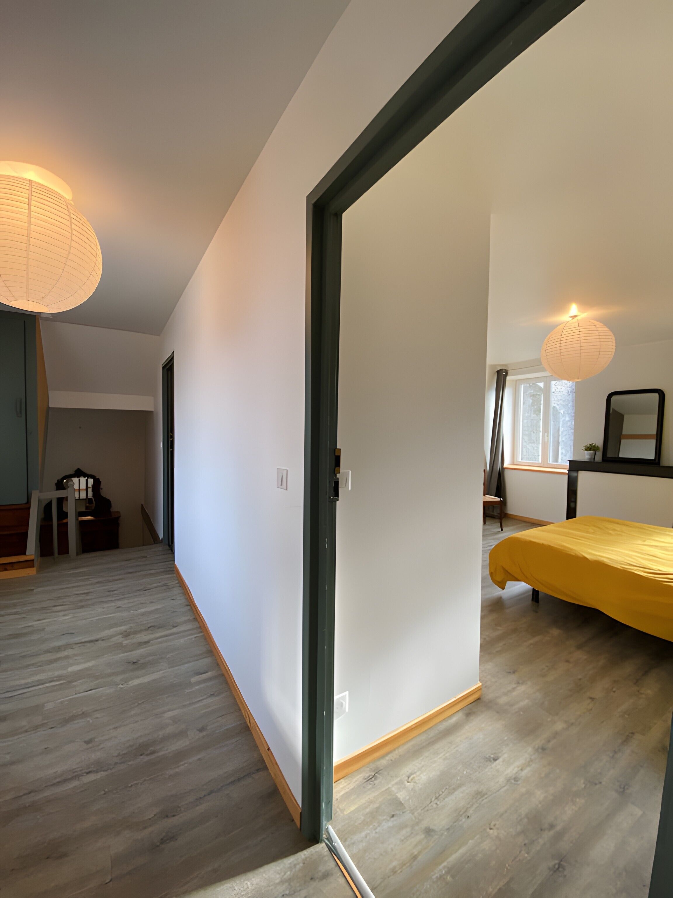 Une pièce comprenant un lit, un bureau, une chaise et une lampe.