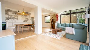 Un amplio espacio de sala con un sofá, una mesa de comedor y sillas.