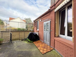 Il s’agit d’une propriété résidentielle dotée d’une entrée sécurisée par un portail, d’une porte en bois et d’une fenêtre ornée d’un cadre décoratif.