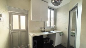 Eine kleine Küche mit Fenster, Spüle und Schränken.