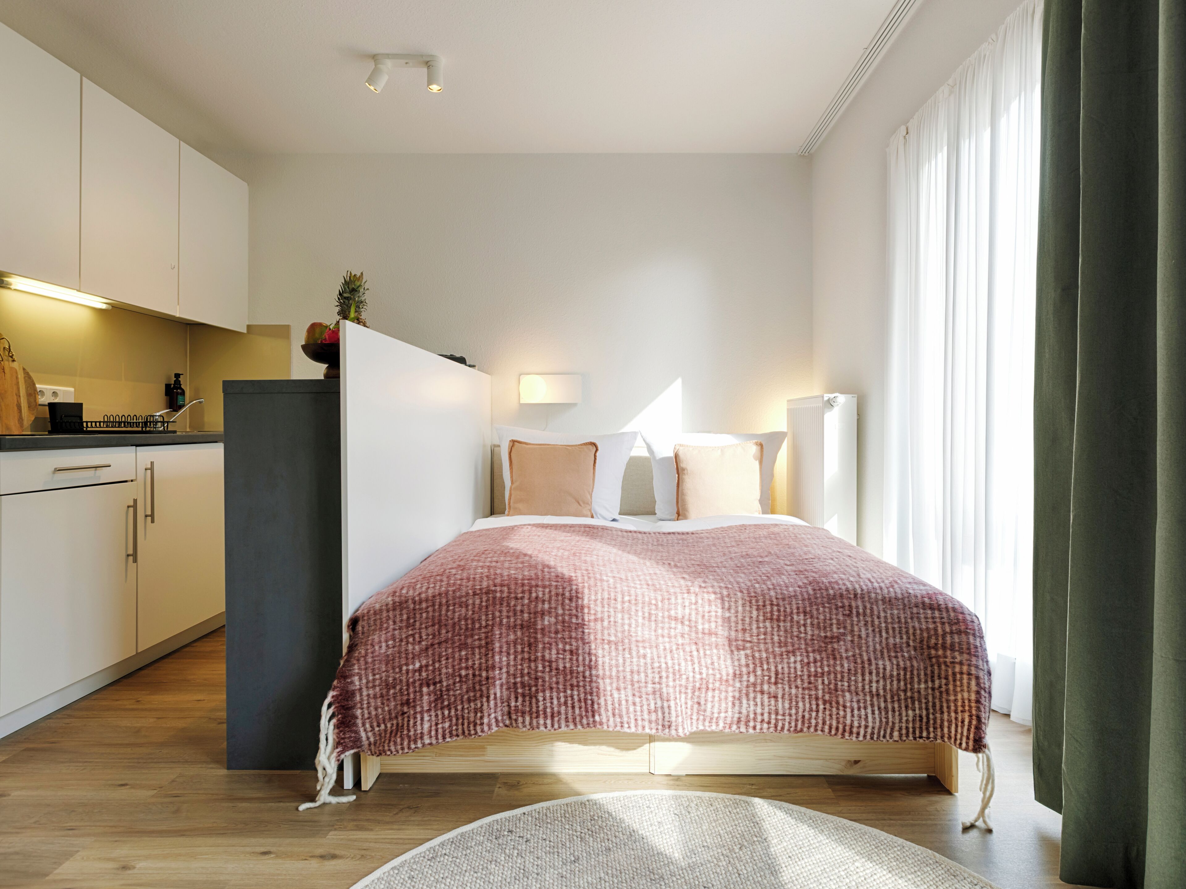 A modern bedroom with a bed, bedside tables, and a window with curtains.