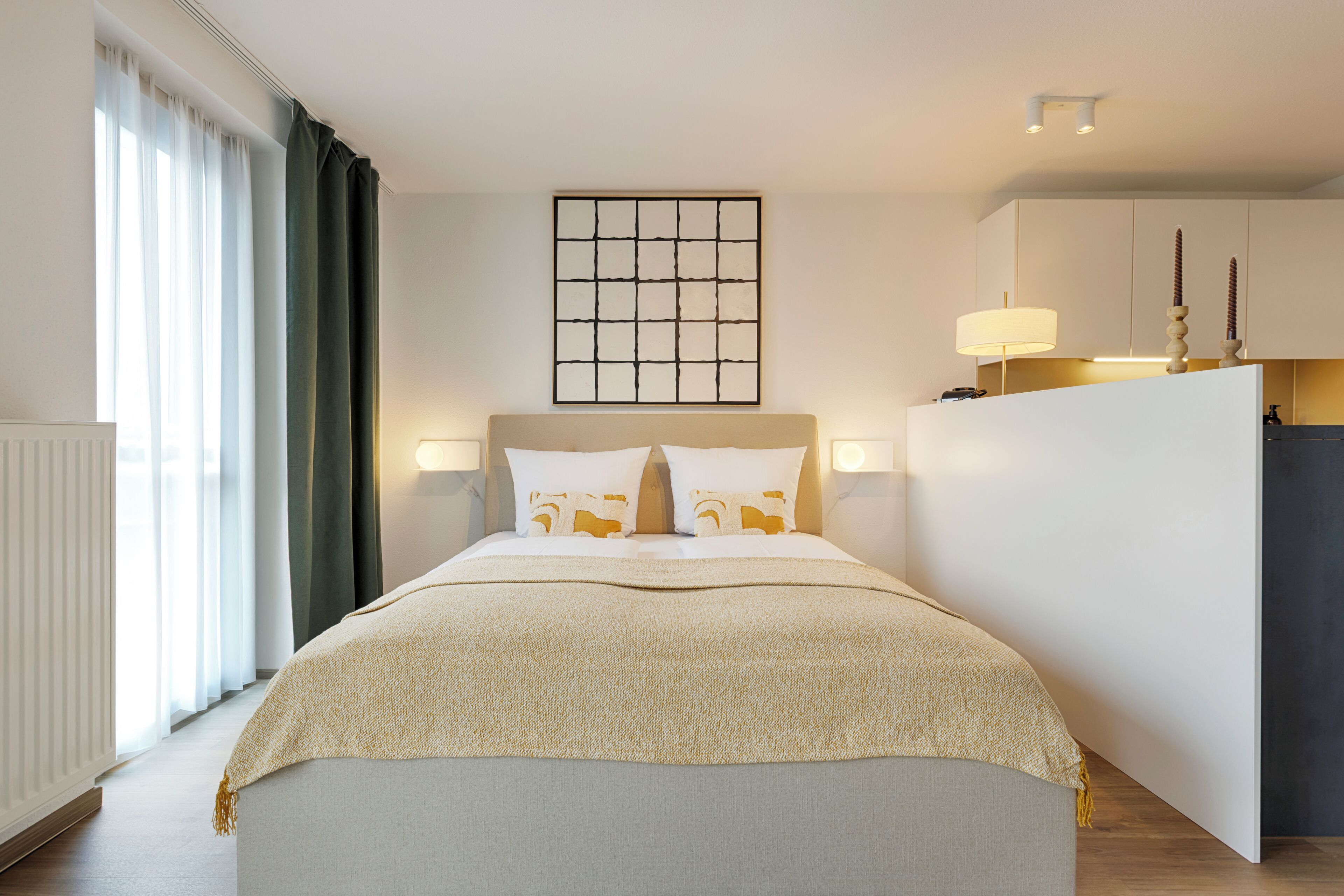 A neatly arranged bedroom with a bed, bedside lamps, a headboard, and a window with curtains.