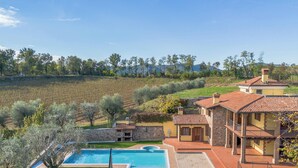 Une villa dotée d’une piscine, de murs en pierre et offrant une vue sur les vignobles.