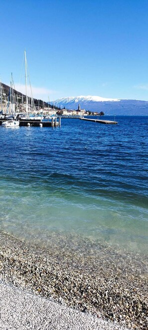 A marina with boats, a clear view of the water, and a distant mountain range. - Apartment in Salò, just a stone's throw from the center (Salò)