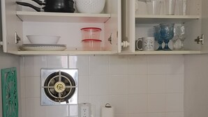 Ett kök med en spis, skåp och ett handfat.