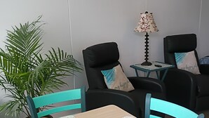 Ett rum med ett bord, två stolar, en lampa och en krukväxt.