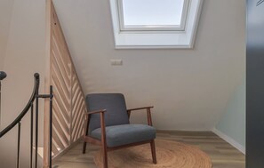 A room with a wooden floor, a chair, a round woven rug, a wooden railing, and a skylight. - Holiday apartment Mar by Lake Sneekermeer (Offingawier)
