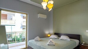 Ein Hotelzimmer mit Bett, Nachttisch, Lampe und Blick auf den Balkon.