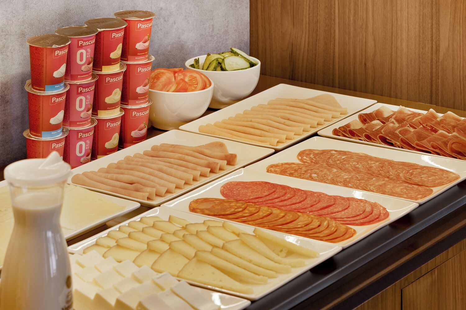 A buffet with various food items including pastries, cheese, and deli meats.