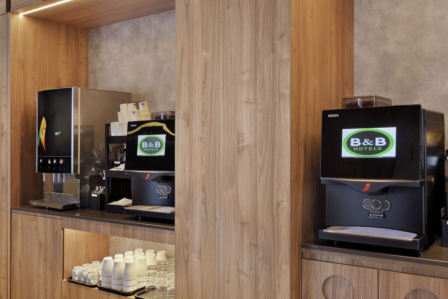 A coffee station with branded dispensers and a tray of disposable cups.